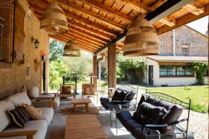 una sala de estar al aire libre con sofás y sillas. en Domaine des Jammetous - Hotel and Yoga Retreat Center, en La Magdelaine-sur-Tarn