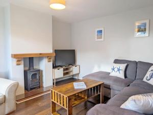 a living room with a couch and a fireplace at Pickleberry Cottage - Close to sandy beach in West Wittering