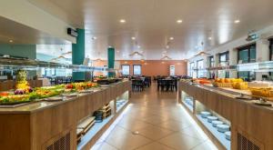 a restaurant with a buffet line with fruits and vegetables at Golden Refúgio das Andorinhas in Cabanas de Tavira