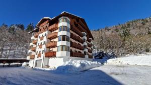 a building with snow in front of it at Apartmány Romantika 7 19 CHOPOK JUH Lux in Horná Lehota
