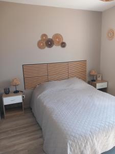 a bedroom with a white bed and two night stands at Maison vacance proche ste mère église in Picauville