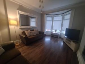 a living room with a couch and a flat screen tv at Coastal stay in South Shields