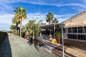 una casa con palme su una strada di Casa Rural EL CAMPICO a Puerto de Mazarrón