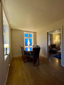 a dining room with a table and chairs and a window at Littahuset in Moskenes