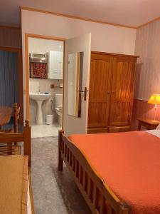 a bedroom with a bed and a bathroom with a sink at Domaine de la Chambre in Verrières