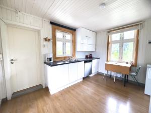 a kitchen with white cabinets and a counter top at Littahuset in Moskenes