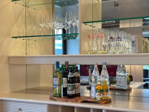 Serenity Stay Baiersbronn Kamin und Schwarzwaldblick في بايرسبرون: يوجد بار به زجاجات واكواب على منضدة +12 صورة