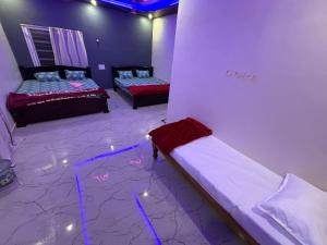 two beds in a room with lights on the floor at Ananya home stay hampi in Hampi