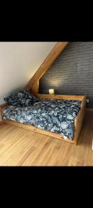 a bed with a wooden frame in a room at Maison vacance proche ste mère église in Picauville