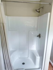 een witte douche in een badkamer met een douchegordijn bij Cascade Inn in Lake Placid