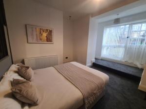 Stylish modern 2 bedroom apartment في سندرلاند: غرفة نوم بسرير كبير ونافذة