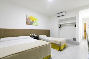 ナタールにあるAtrios Beach Hotelのベッドが2つと窓があるホテルの部屋