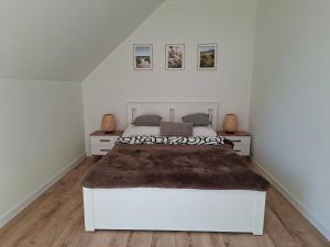 Un dormitorio con una gran cama blanca en una habitación. en Lake House Szteklin, en Szteklin