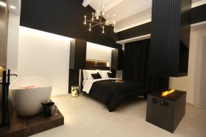 a black and white bedroom with a bed and a bath tub at B&B Il Moro Luxury Rooms in Syracuse