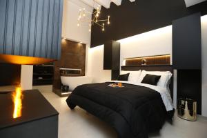 a bedroom with a black bed and a fireplace at B&B Il Moro Luxury Rooms in Syracuse