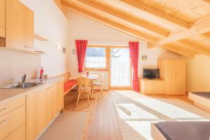 una cucina con un lavello e un tavolo con sedie di Inner Glieshof a Mazia