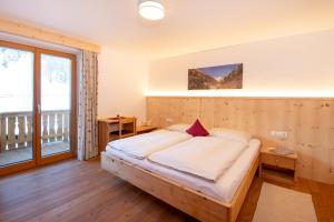 una camera da letto con un letto e una grande finestra di Inner Glieshof a Mazia