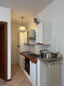 a kitchen with white cabinets and a stove top oven at Appartamento Amendola in Luino +8 photos