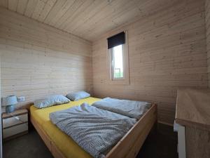 a bedroom with a bed in a wooden room at Domki Śnieżka in Wojcieszyce +101 photos