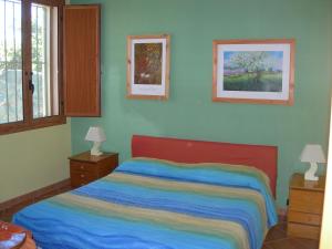 sypialnia z łóżkiem z kolorowym kocem w obiekcie Villa Belfronte w mieście Floridia