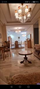 a living room with a table and a chandelier at guiliz in Marrakech