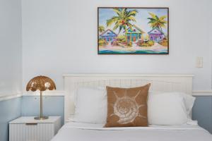 ein Schlafzimmer mit einem Bett mit einem Bild an der Wand in der Unterkunft Sabal Palms Inn in St Pete Beach