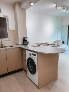 una cocina con lavadora bajo una barra en Bolivar, en Mar del Plata