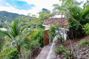 una pequeña casa con una puerta en un jardín en A Slice of Paradise, en Tapantí 8 fotos más