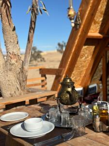 a table with plates and a tea pot on it at Elhamma Resort Studio in Tozeur