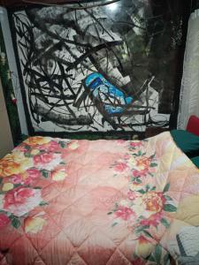 a bed with a flowery quilt on top of it at Habitación doble- cama dos plazas in Los Ángeles