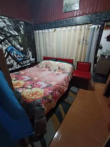 a bedroom with a bed and a red chair at Habitación doble- cama dos plazas in Los Ángeles