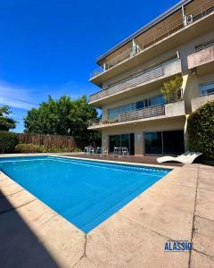 a swimming pool in front of a building at Departamento Alassio in Tigre