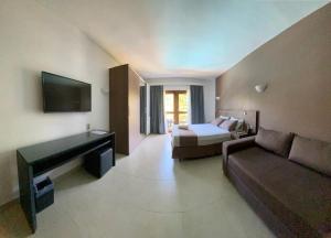 a hotel room with a bed and a couch and a bed and a desk at Wind e Blue in Jericoacoara