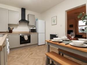 a kitchen with a table and a kitchen with white appliances at Levenside in Garstang
