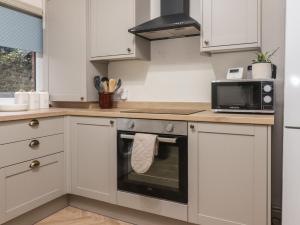 a kitchen with a stove and a microwave at Levenside in Garstang +14 photos