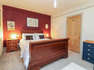 a bedroom with a large bed with red walls at Levenside in Garstang