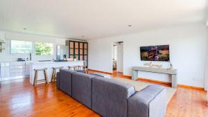a living room with a couch and a kitchen at Hideaway in Herolds Bay