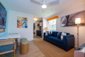 منتجع صن شاين سويتس في جورج تاون: غرفة معيشة مع أريكة زرقاء وطاولة