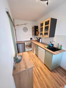 a kitchen with a sink and a wooden floor at Ruhiges Apartment Leipziger Neuseenland, direkte S-Bahn Anbindung Leipzig sowie Messe in Neukieritzsch
