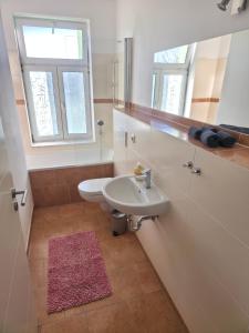 a bathroom with a sink and a toilet and a window at Ruhiges Apartment Leipziger Neuseenland, direkte S-Bahn Anbindung Leipzig sowie Messe in Neukieritzsch