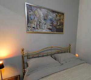 a bedroom with a bed with a picture on the wall at By Domy 2 Grottaglie in Grottaglie