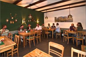 un grupo de personas sentadas en mesas en un restaurante en Altstadthotel Bauern Bräu Schrobenhausen, en Schrobenhausen