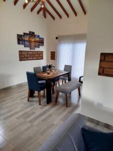 a dining room with a table and chairs and a couch at Cabaña in Sáchica +6 photos