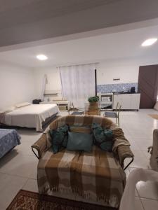a living room with a couch and a bed at Brusque Comfort Studios in Brusque