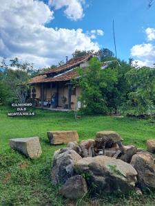 a building with a bunch of rocks in a yard at Caminho das Montanhas eco in Itanhandu