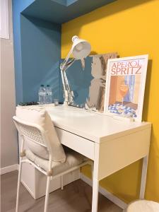 a white desk with a lamp and a chair at B&B Pizza Room Twin Room near Navigli Milan in Milan