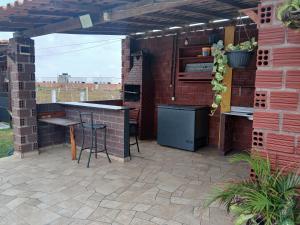 a patio with an outdoor kitchen with a brick wall at Chalé 02 Cantinho do Céu- Santo Amaro do MA in Santo Amaro