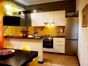 a kitchen with white cabinets and a refrigerator and a table at Happy Home BO Fiera Self Check-in in Bologna