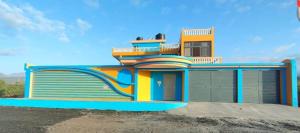 a colorful house with a fence around it at Residencial oliveira in Porto Novo