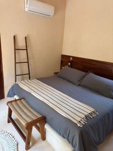 a bedroom with a bed with a chair and a ladder at Villas Indigo Troncones in Troncones